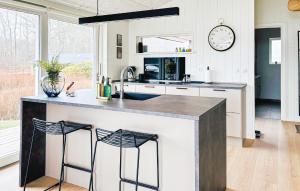 a kitchen with a large counter with two stools at 3 Bedroom Awesome Home In Haderslev in Haderslev