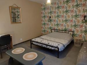 a small bedroom with a bed and a table at Gite les Campanules in Monthermé