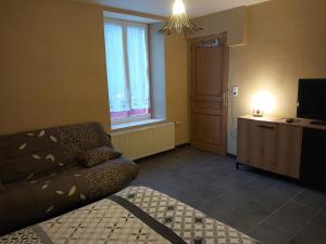a living room with a couch and a television at Gite les Campanules in Monthermé