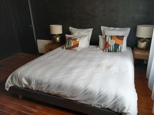 a large bed with white sheets and pillows at la penombre spa in Abbeville
