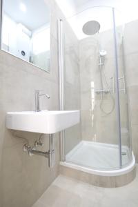 a bathroom with a sink and a shower at Toplage beim Rathaus Grace Royal Designsuite in Vienna +11 photos