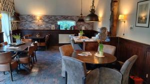 a restaurant with tables and chairs in a room at Bij Aquamarijn in Stieltjeskanaal