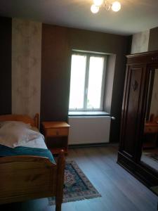 a bedroom with a bed and a window at chambre en colocation in Bust +2 photos