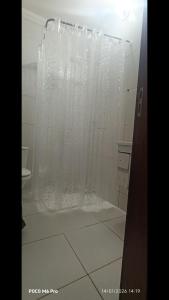 a shower with a curtain in a bathroom at Casa 02 Cantinho e Sossego in Vespasiano