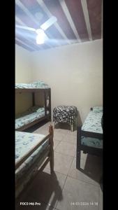 a room with three beds in a room at Casa 02 Cantinho e Sossego in Vespasiano