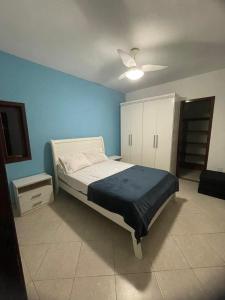 a bedroom with a bed and a blue wall at CAIPORA Hostel Lagoa in Saquarema