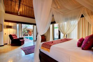 a bedroom with a bed with a canopy at Manzelejepun Luxury Villa & Pavilion in Sanur