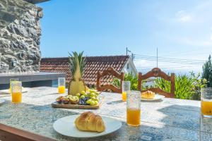 a table with plates of food and orange juice at Casa da Horta by Atlantic Holiday in Santa Cruz