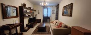 a living room with a couch and a tv at La Casa delle Liane in Galatina