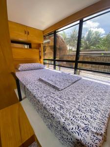 a bed in a room with a large window at Journeyy INN in General Luna