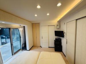 a large room with a bed and a tv in it at SnowMapleHouse西川口 in Kawaguchi