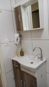 a bathroom sink with a hair dryer and a mirror at Chalé Paraíso Da Serra 02 in Gramado