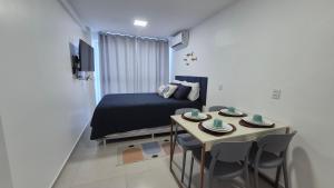 a bedroom with a bed and a table with plates on it at Studio Mare Alta in Tamandaré