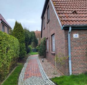 a brick walkway next to a brick building at lüttje Meerzeithuus in Carolinensiel
