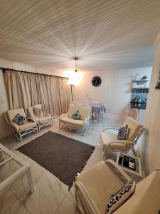 a living room with chairs and a table in a room at The Oyster Cove in Brenton-on-Sea +42 photos