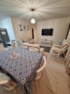 a living room with a table and chairs and a television at The Oyster Cove in Brenton-on-Sea