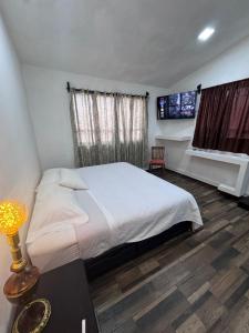a bedroom with a large bed and a television at Hotel CALLI YOLOTL Teotihuacan in San Juan Teotihuacán
