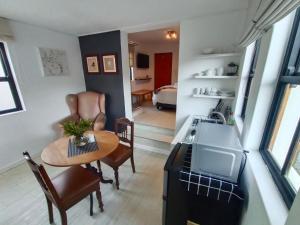 a kitchen and living room with a table and a sink at Die Nagmaalhuisie in Montagu