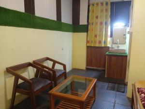 two chairs and a glass table in a room at Gokarna City Guest House in Gokarna