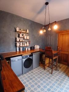 a kitchen with a table and a dishwasher and a table and chair at Chambre bleue avec accès plage in Bourges