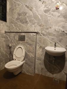 a bathroom with a toilet and a sink at Two Heart heaven in Covelong