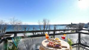 a table on a balcony with a view of the water at Desenzanoloft Garda Golden Sunrise official partner Homes and Villas By Marriott Bonvoy in Desenzano del Garda