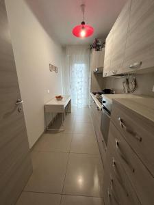 a kitchen with a table and a red light at Il Mare a due Passi in Pesaro