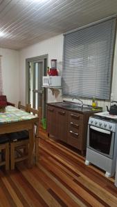 a kitchen with a stove and a table with a table sidx sidx at Chalé Paraíso Da Serra 02 in Gramado +7 photos