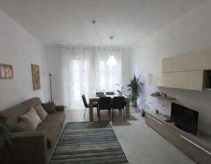 a living room with a couch and a dining room table at Il Mare a due Passi in Pesaro