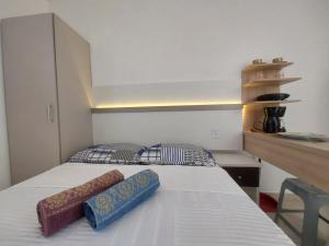 a bedroom with a bed with two pillows on it at Microcasa loft in São Pedro da Aldeia
