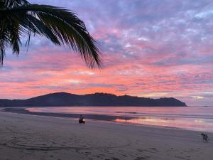 a person riding a motorcycle on the beach at sunset at Emil's Beach Cottage in El Nido