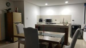 a kitchen with a table and a kitchen with a refrigerator at Casa o Habitación in Villeta +5 photos