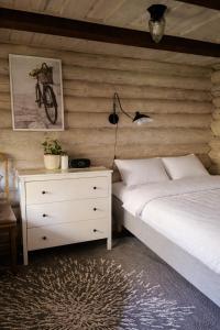 a bedroom with a bed and a dresser and a lamp at Sepasauna holiday house in Joaveski