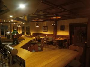 a restaurant with tables and chairs and a bar at Hotel Büker in Erwitte