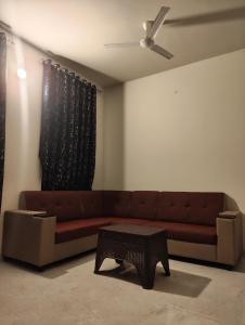 a living room with a brown couch and a table at Two Heart heaven in Covelong +1 photo