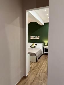 a bedroom with a bed and a green wall at Titti's Nest in Casteldaccia