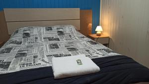 a bed with a newspaper on it with a towel on it at Chalé Paraíso Da Serra 02 in Gramado