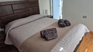 a bedroom with a bed with towels on it at Alojamiento Costanera in Laraquete