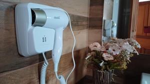 a phone is attached to a wall with flowers at Pouso Flor da serra in Tiradentes