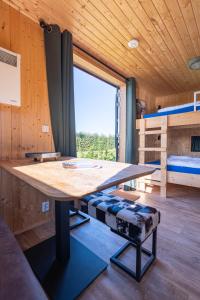 a large wooden table in a room with a bed at Tinyhouse Spiegelpeer in Ruinerwold