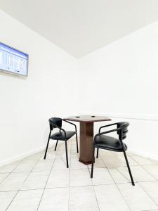 a table and two chairs in a room at Golfinho Hotel in São Vicente