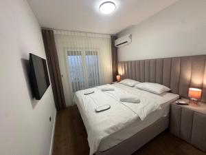 a bedroom with a large bed with white sheets and pillows at Seafront apartment Tivat in Donja Lastva