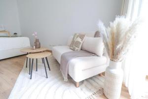 a living room with a white couch and a table at Toplage beim Rathaus Grace Royal Designsuite in Vienna