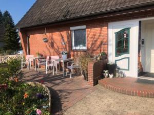 a patio with tables and chairs in front of a house at Gemütliches Inselnest mit großer Terrasse nahe Nordsee& Hafen in Tönning