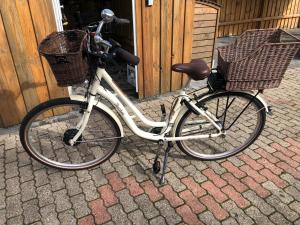 a bike with two baskets is parked on a sidewalk at Gemütliches Inselnest mit großer Terrasse nahe Nordsee& Hafen in Tönning