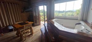 a large bath tub in a room with a window at Pousada Chales Rancho Caipira in Santo Antônio do Pinhal +60 photos