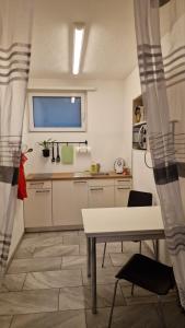 a kitchen with a table and a tv on the wall at Apartment Ferreira in Iseltwald