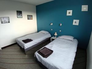 two beds in a room with blue walls at Maison 6 pers proche plage de Tanchet in La Pironnière