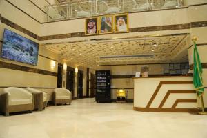 a lobby with a waiting room with chairs and a counter at جوهرة مكة الفندقية in An Naqāʼ