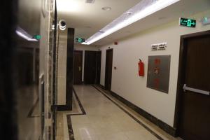 an empty hallway with a fire extinguisher on the wall at جوهرة مكة الفندقية in An Naqāʼ +10 photos